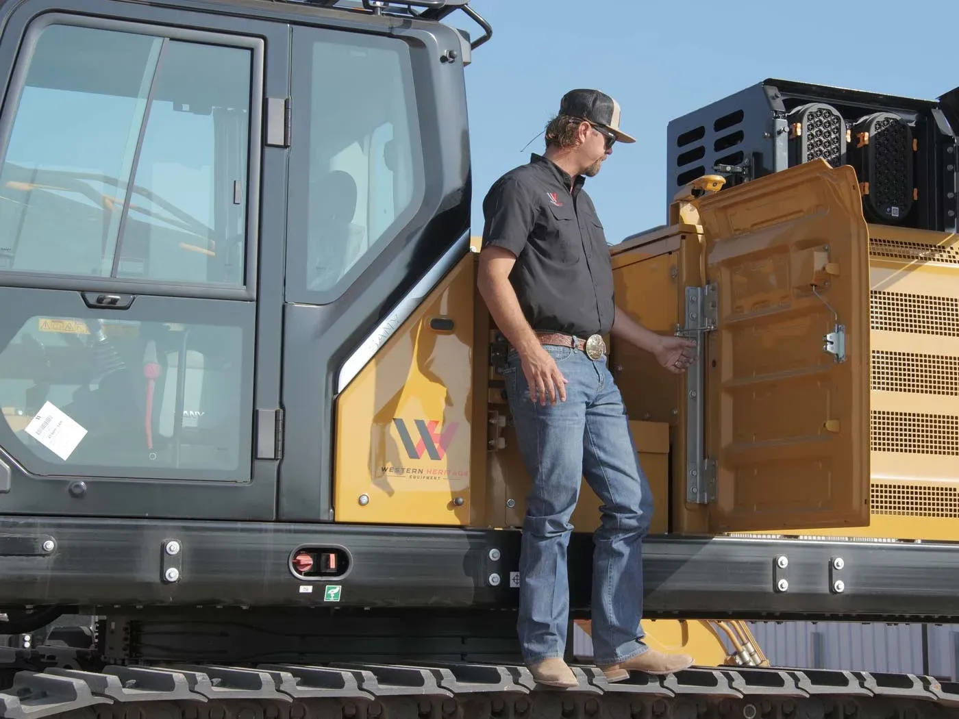 A Western Heritage Equipment team member stepping down from the track of a SANY excavator.